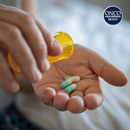 Mano con medicamentos para tratar osteoporosis.