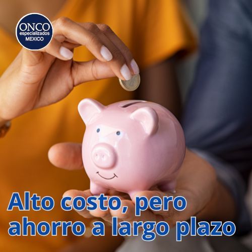 Mano colocando moneda en alcancía rosa.