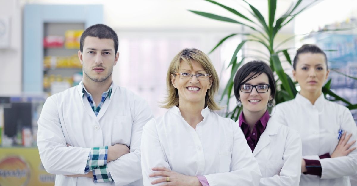 Un grupo de farmacéuticos posa para una fotografÃa en una farmacia.