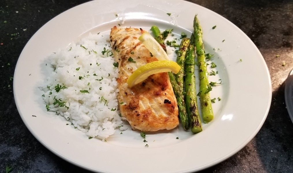 A plate of food with rice and asparagus on a table