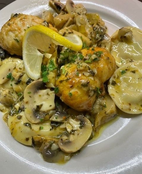 A close up of a plate of food with a lemon slice on top