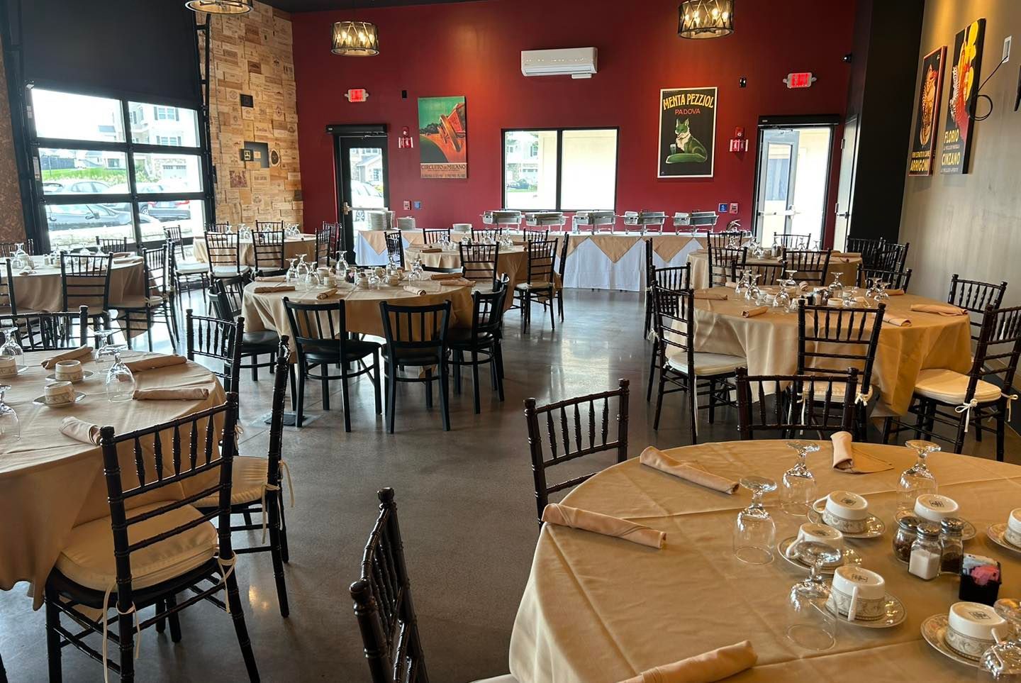 A large dining room with tables and chairs set up for a wedding reception.