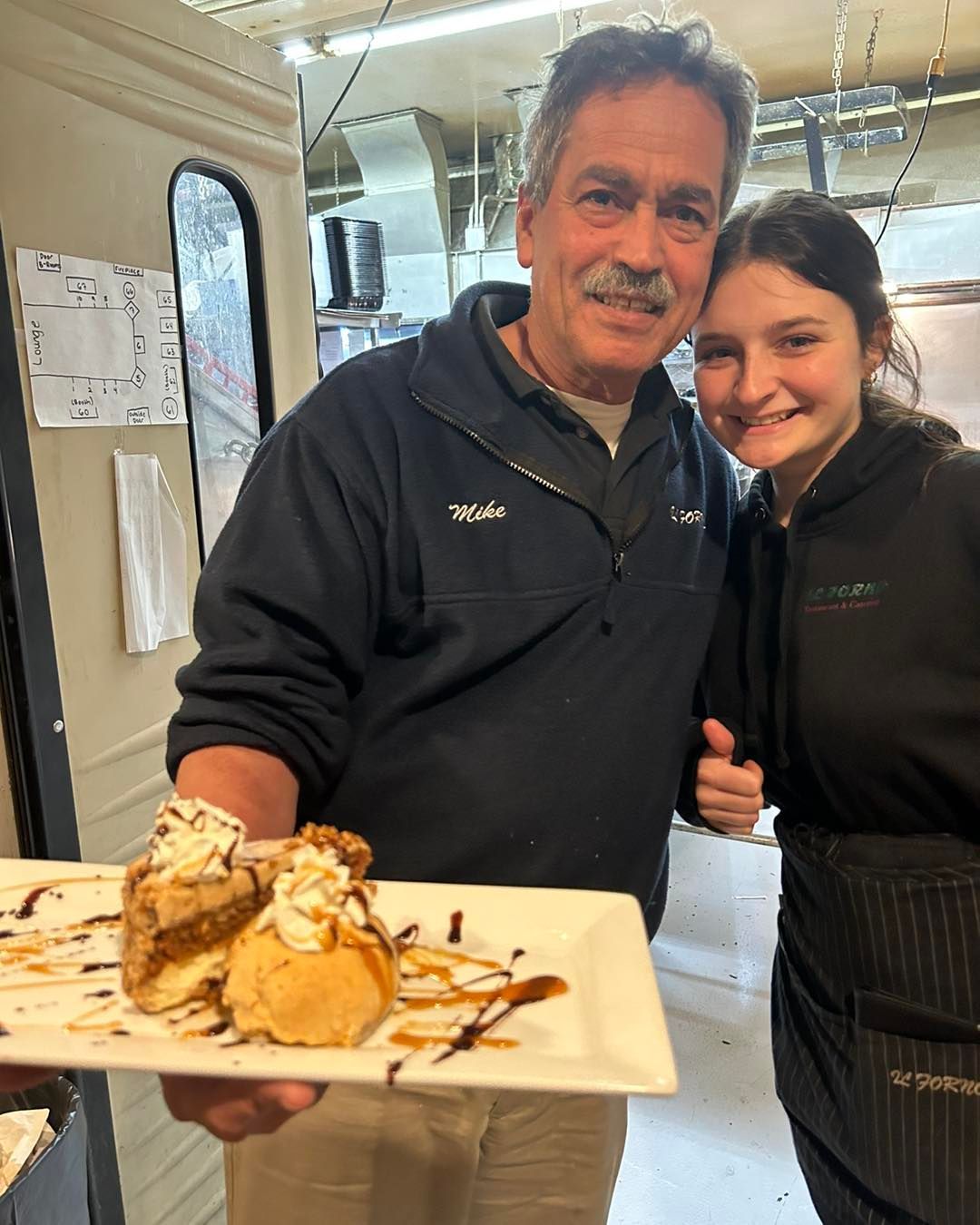 A man holding a plate of food next to a woman