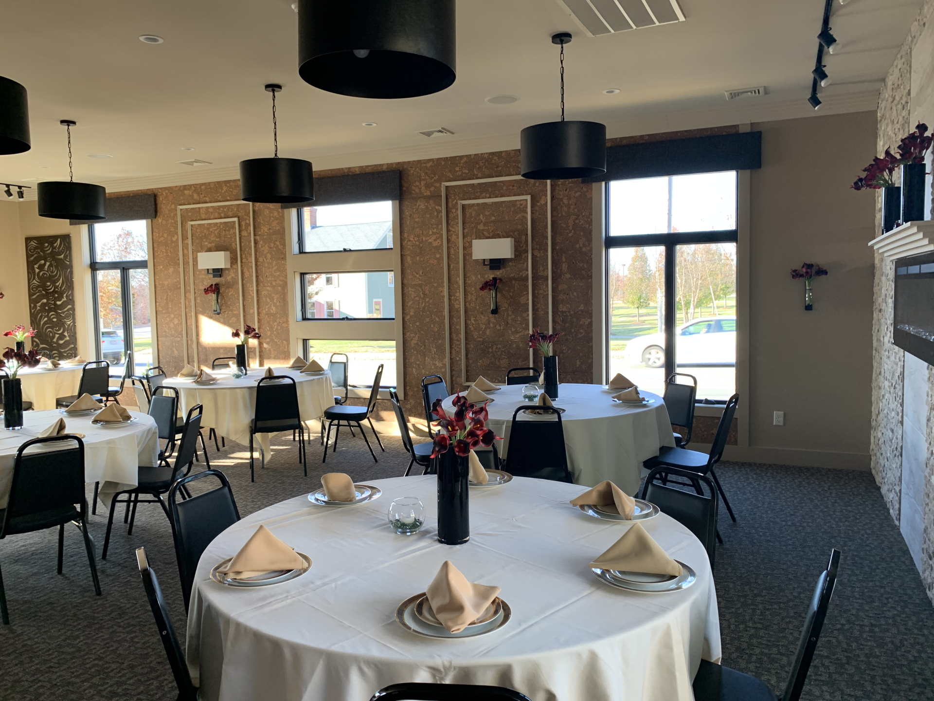 A large room with tables and chairs set up for a wedding reception.