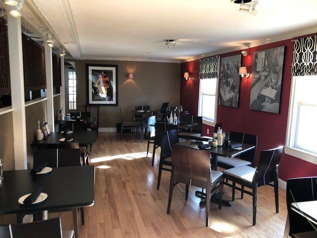 A restaurant with tables and chairs and a picture on the wall