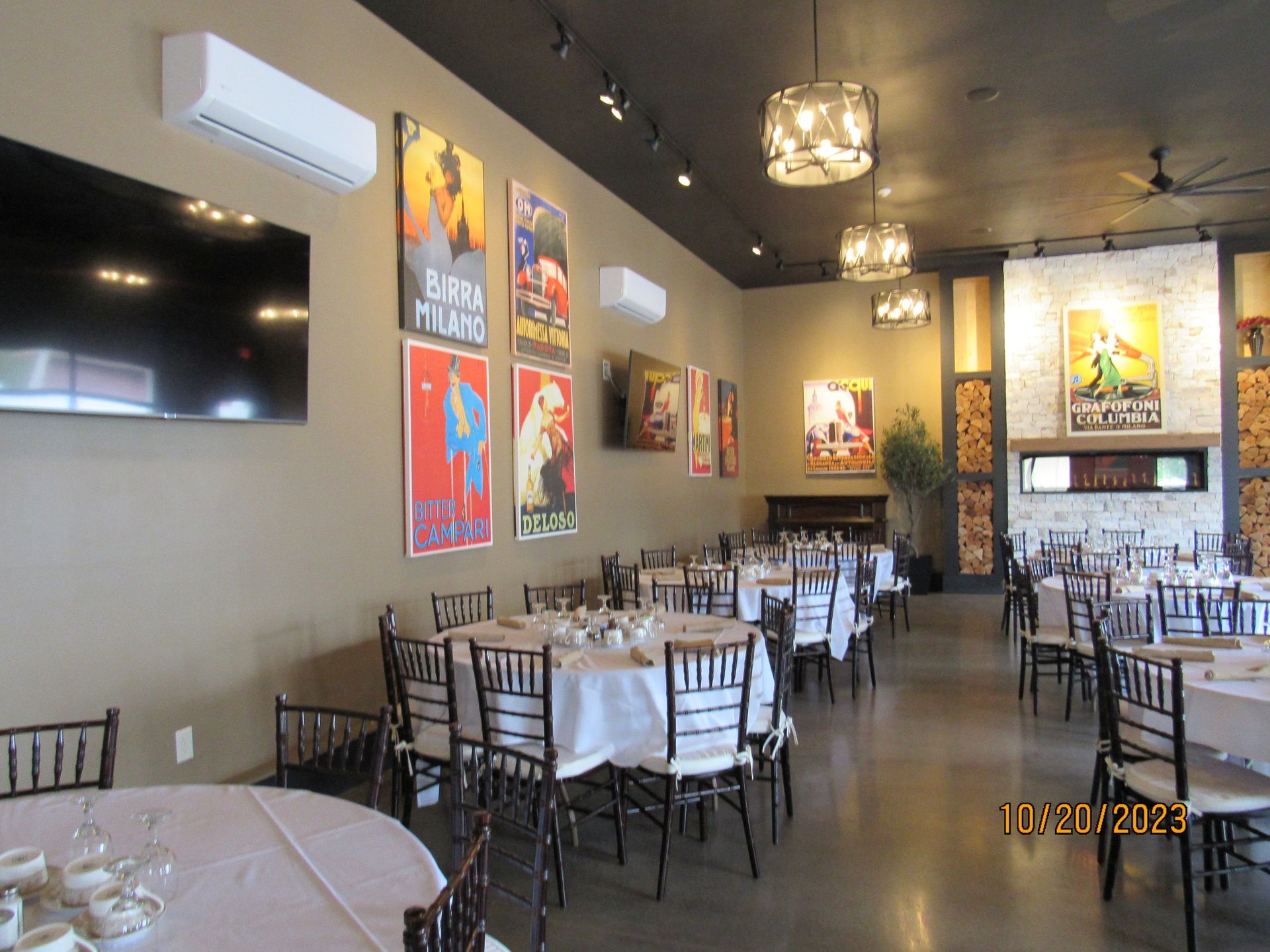 A large dining room with tables and chairs and posters on the wall.