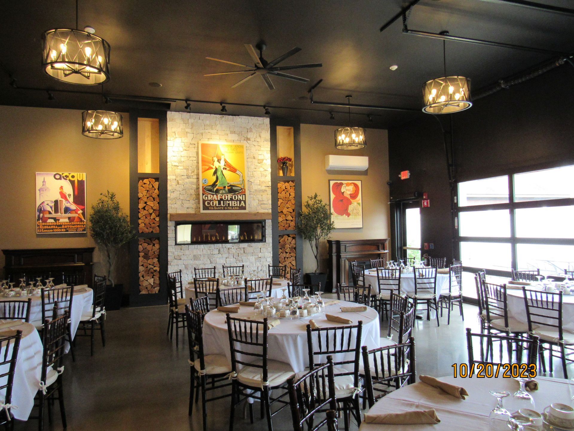 A large dining room with tables and chairs and a fireplace