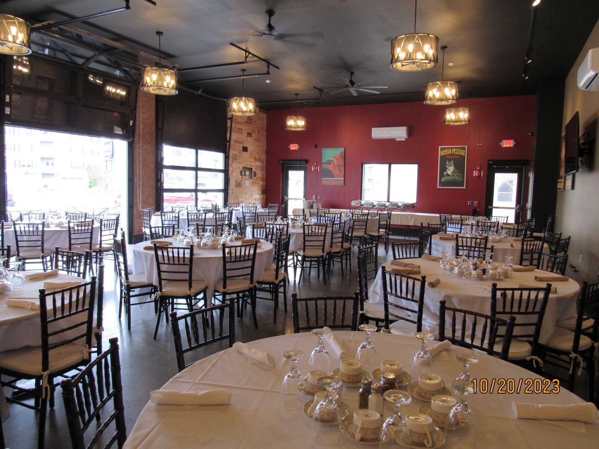 A large dining room with tables and chairs set up for a wedding reception.