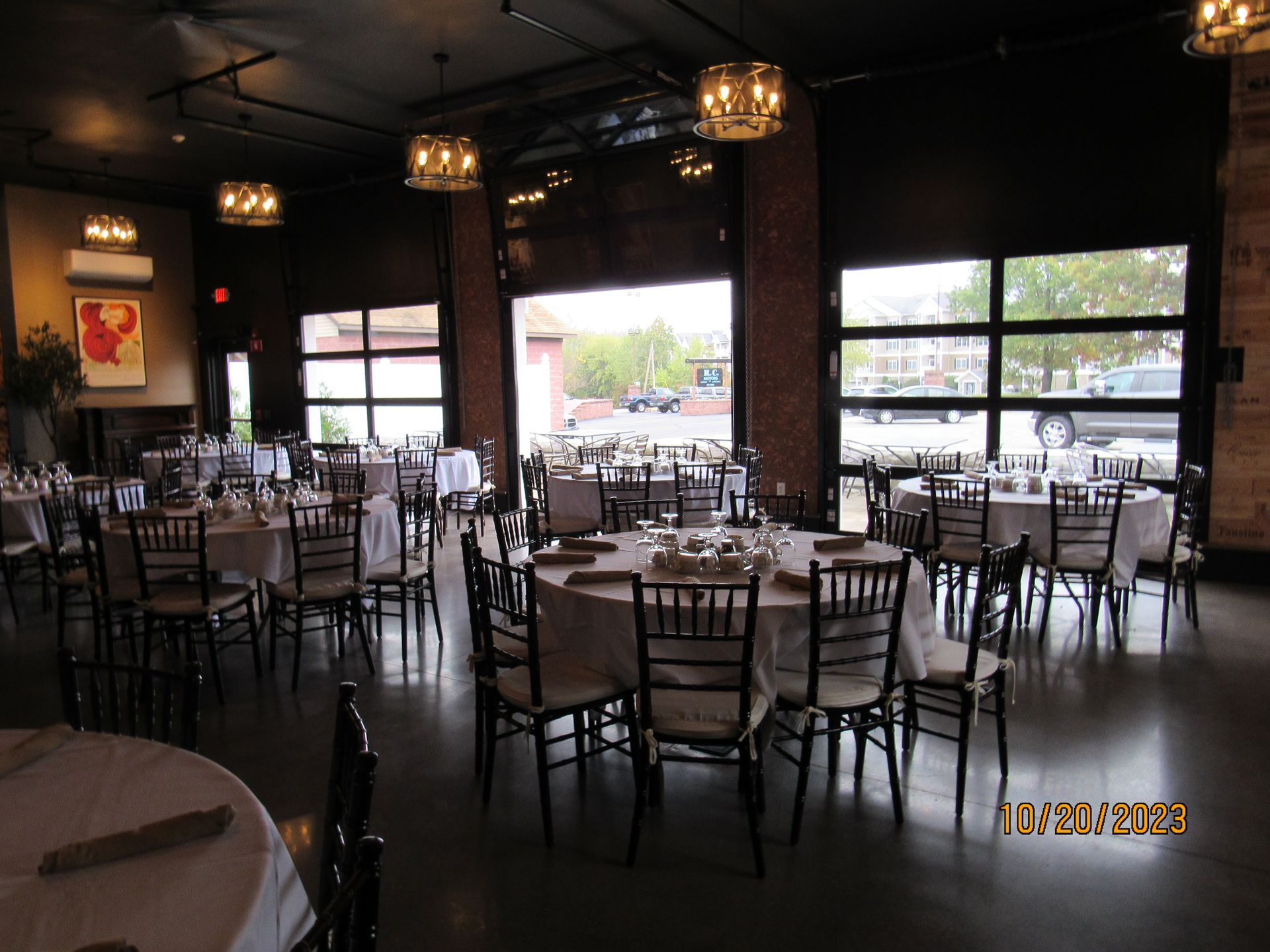 A large room with tables and chairs set up for a wedding reception.