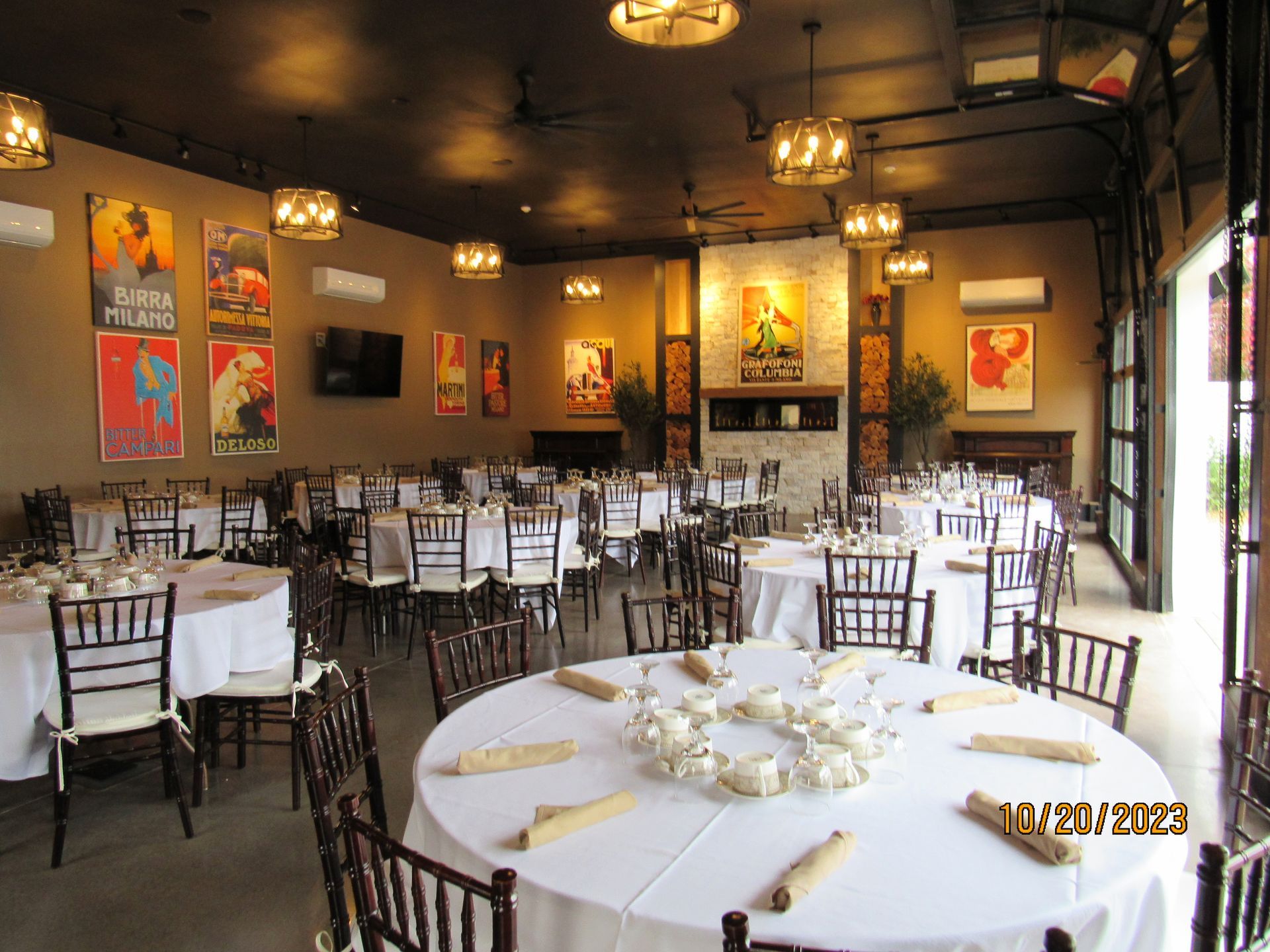 A large room with tables and chairs set up for a wedding reception.