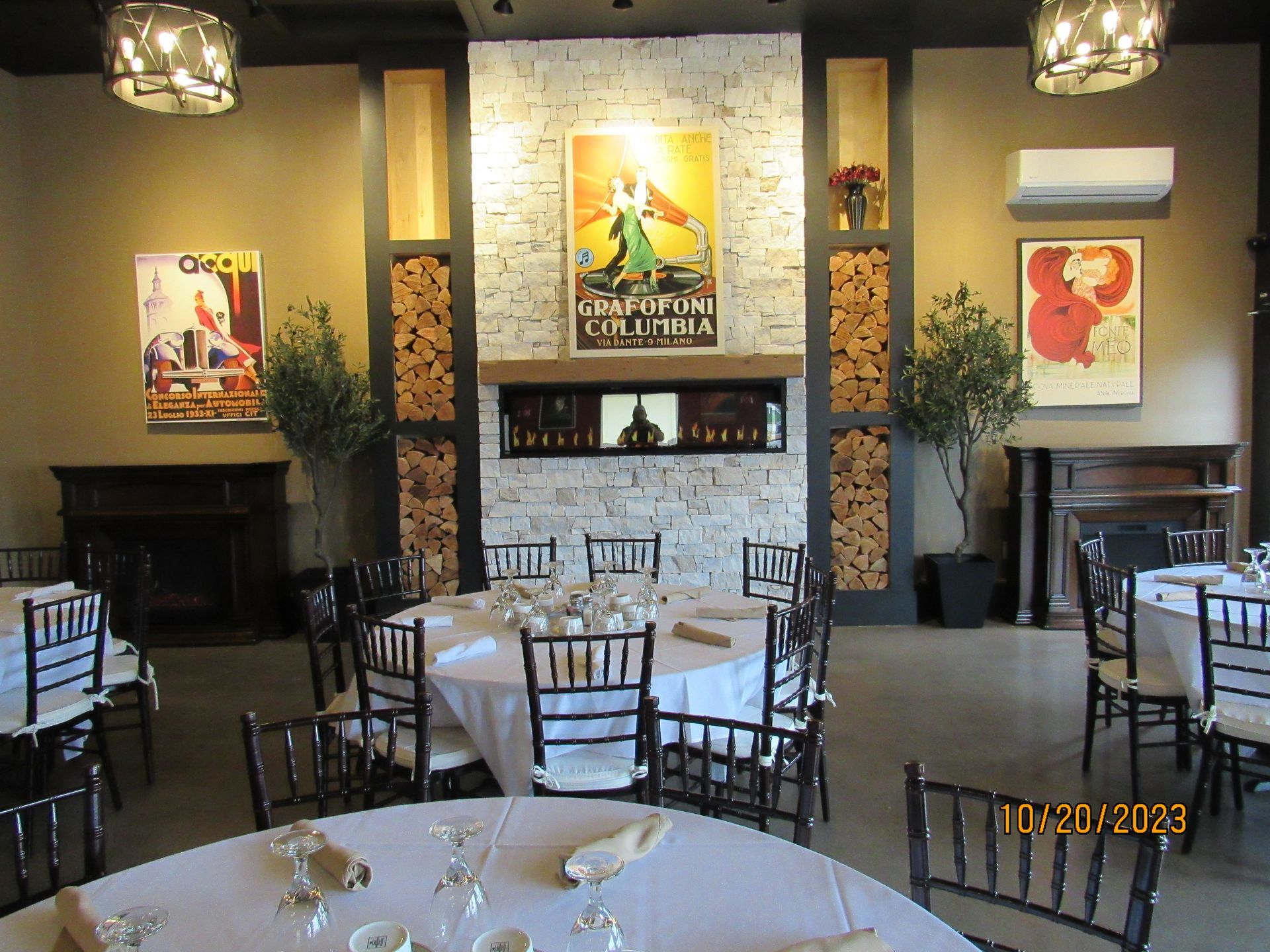 A large room with tables and chairs and a fireplace