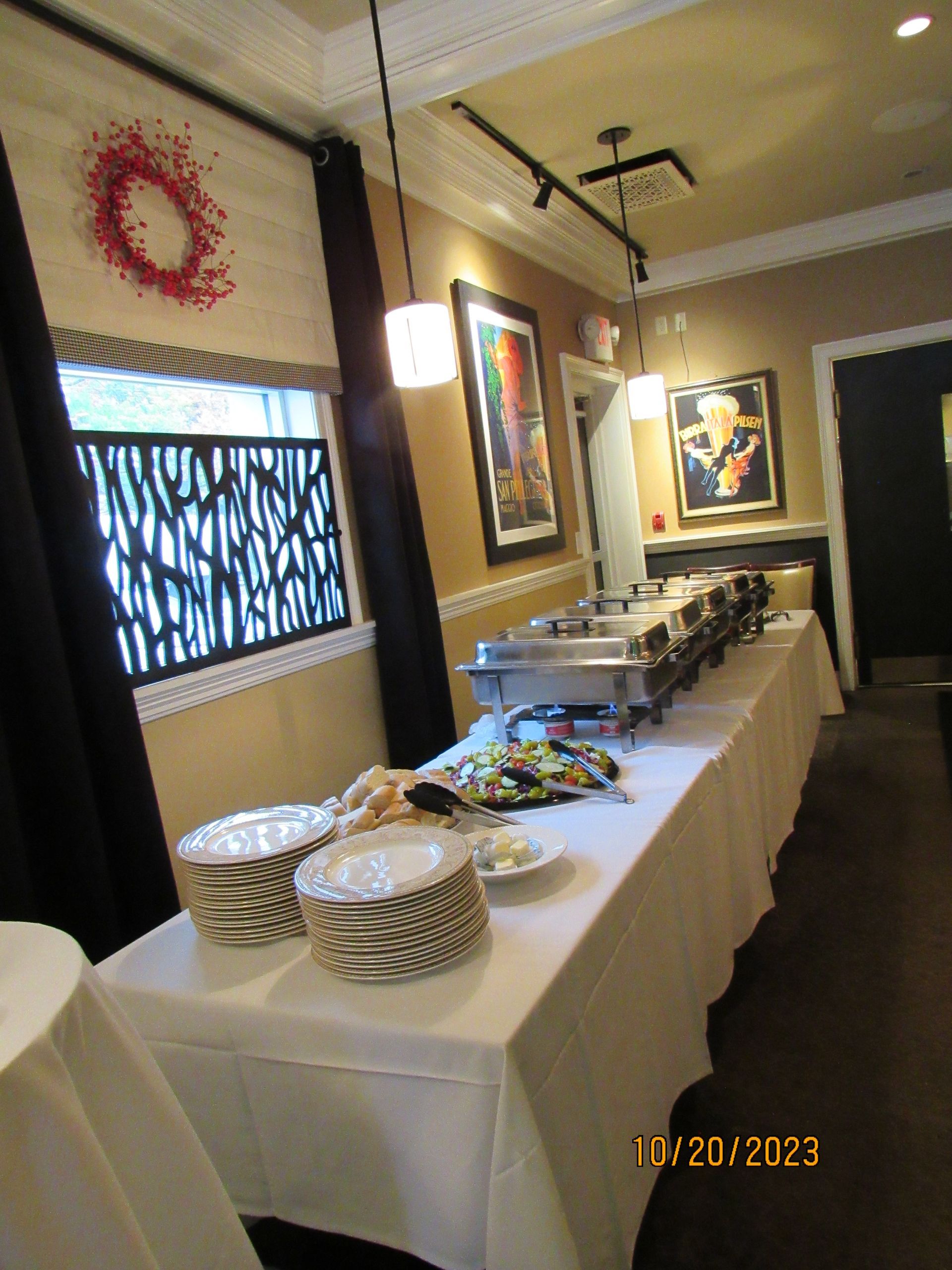 A long buffet table with plates and utensils on it