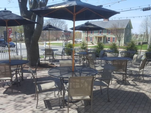 A patio area with tables and chairs and umbrellas