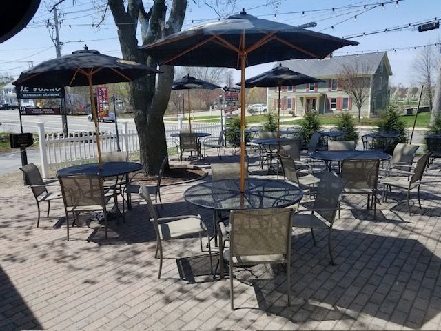 A patio area with tables and chairs and umbrellas