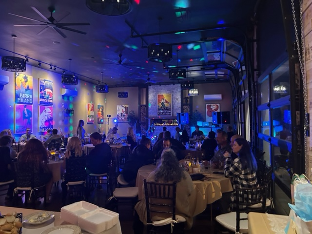 A group of people are sitting at tables in a restaurant.