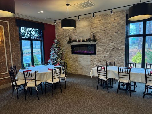 A dining room with tables and chairs and a fireplace.