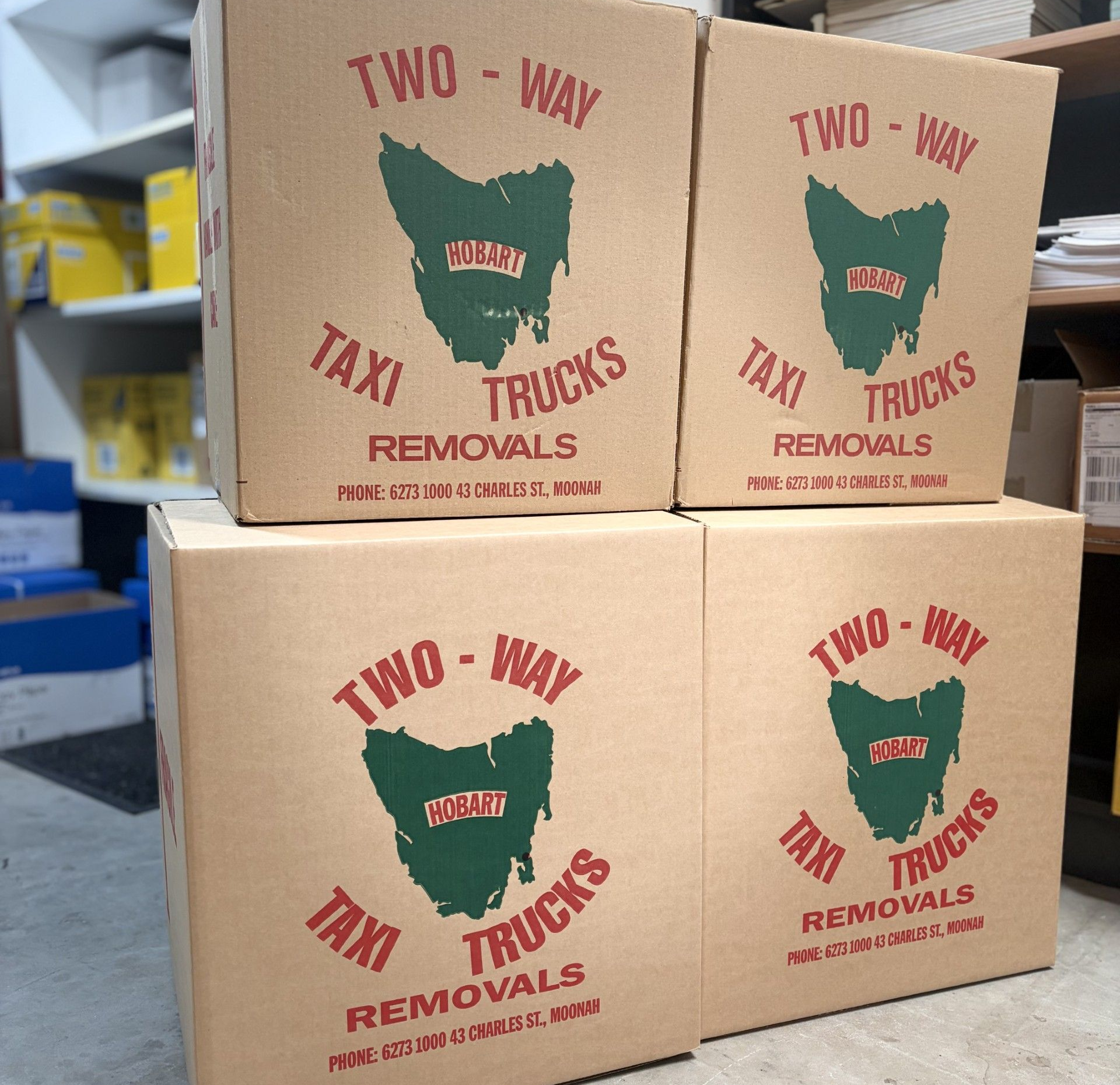 Four cardboard boxes stacked, each labeled Four cardboard boxes stacked, each labeled