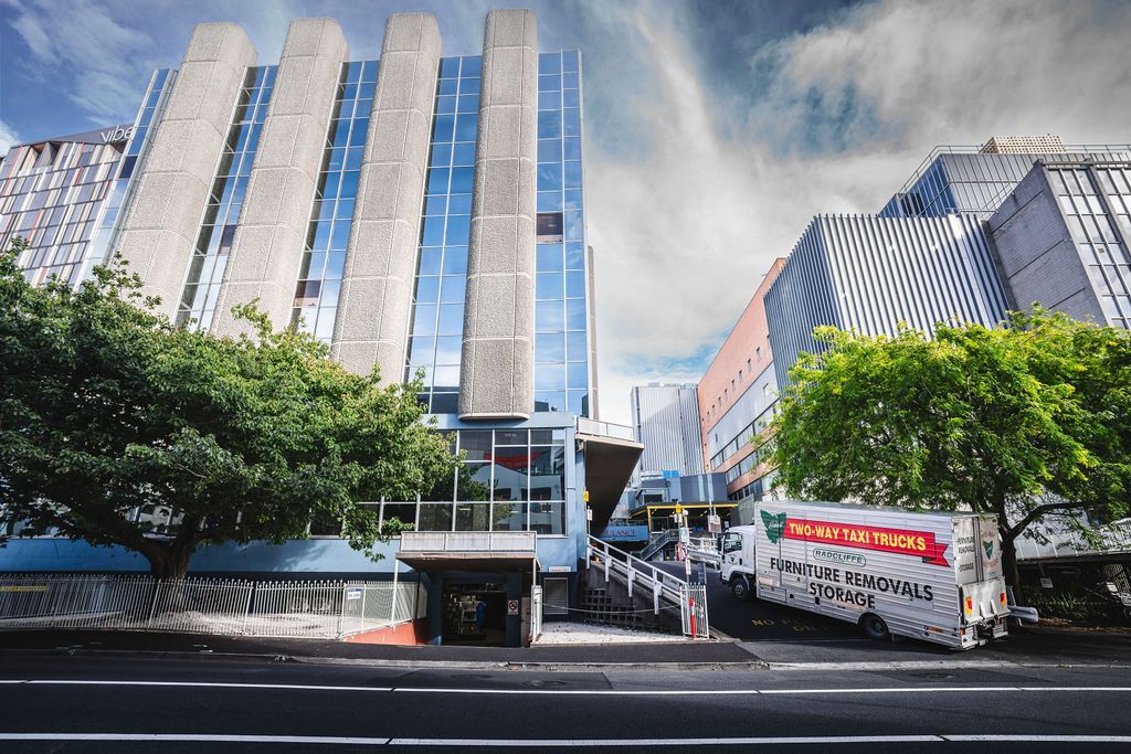 Room with boxed items and covered furniture during a move.