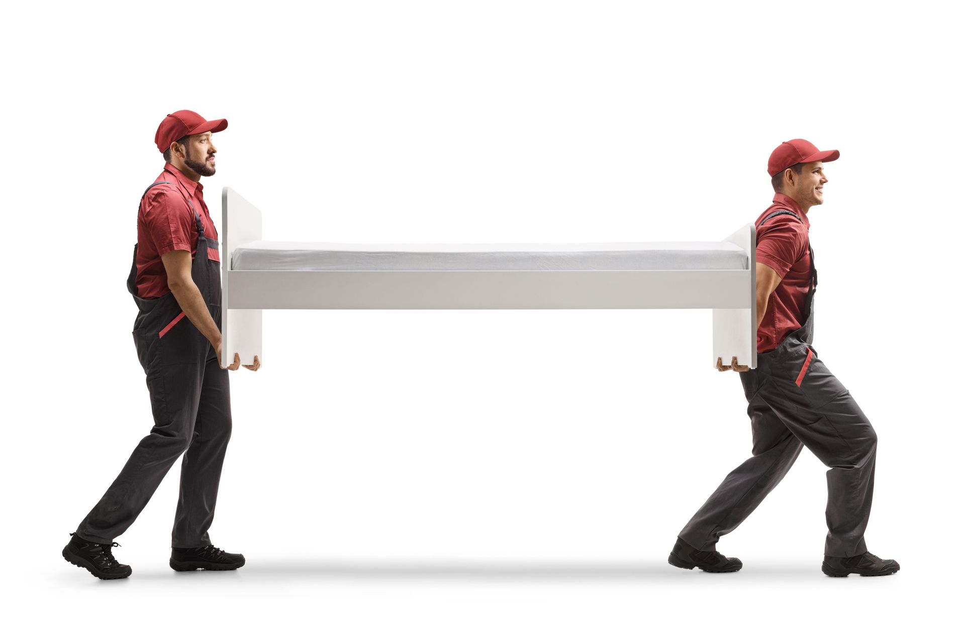 Two movers in red uniforms carry a white bed frame against a plain white background Two movers in red uniforms carry a white bed frame against a plain white background