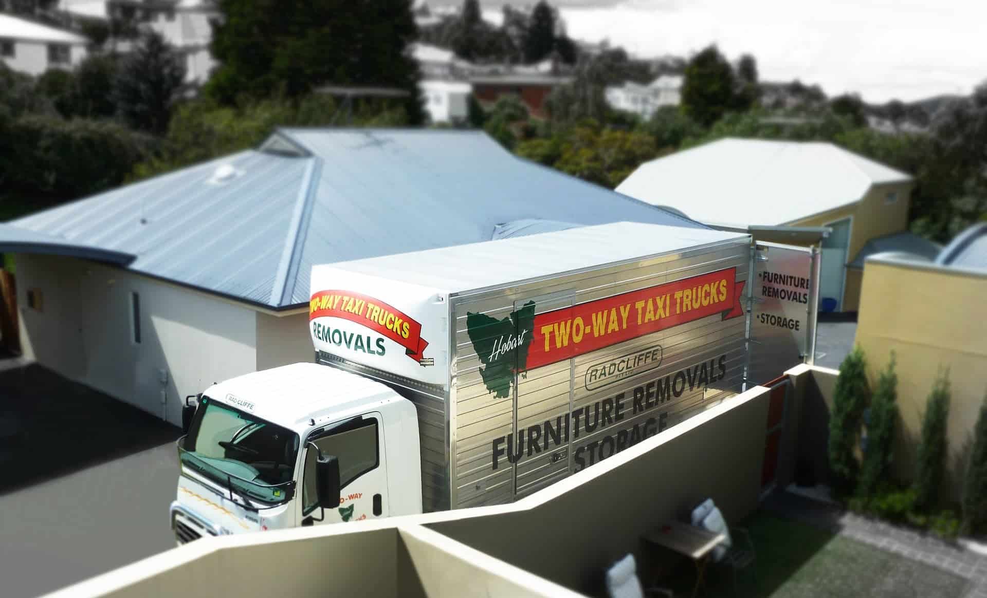 Two men assembling furniture in a modern living room with large windows.