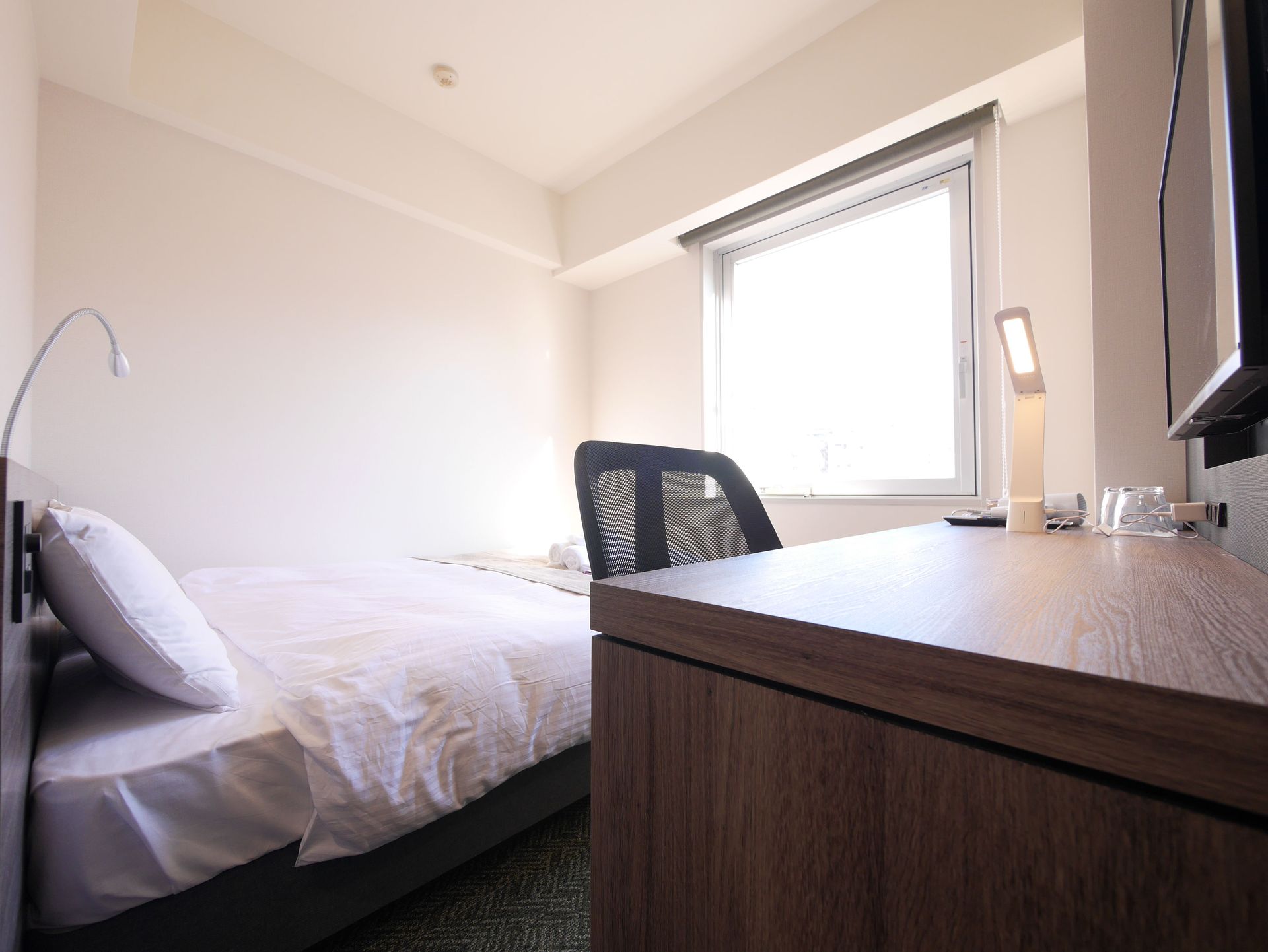 Double room with bed and wall-mounted TV at Comfybed Ginza