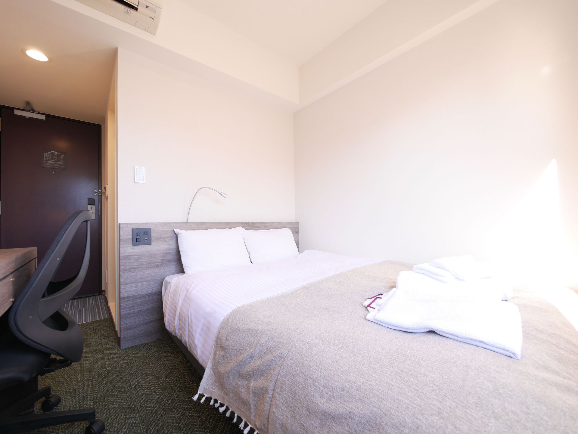 Double room with bed, nightstand and lighting at Comfybed Ginza