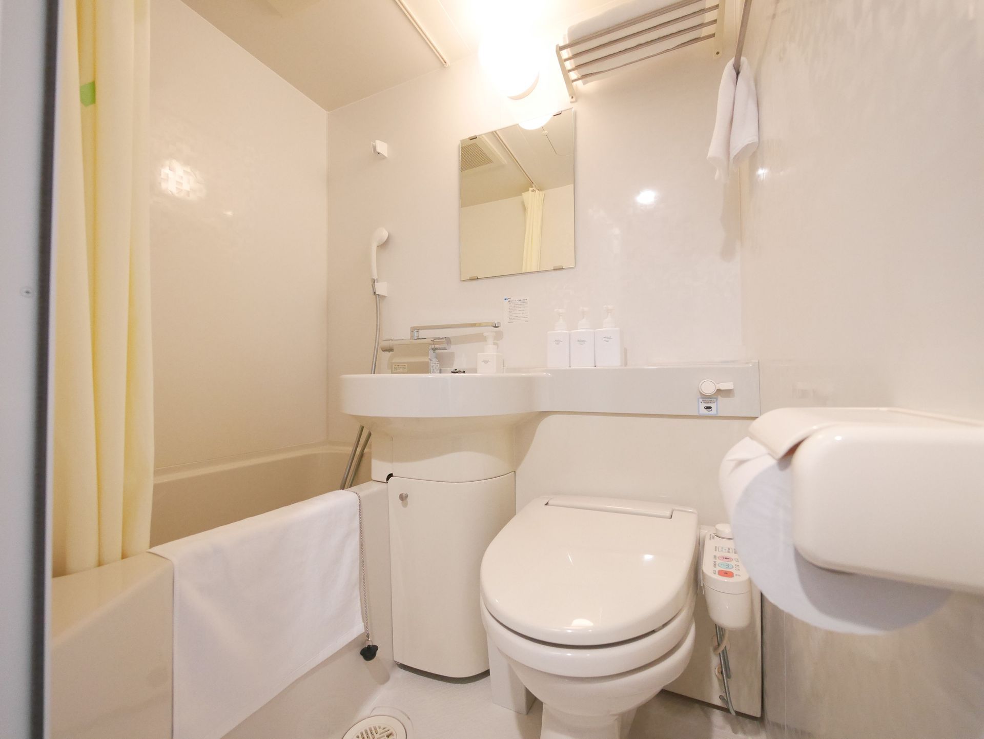 Compact single guest room with mirror and soft lighting