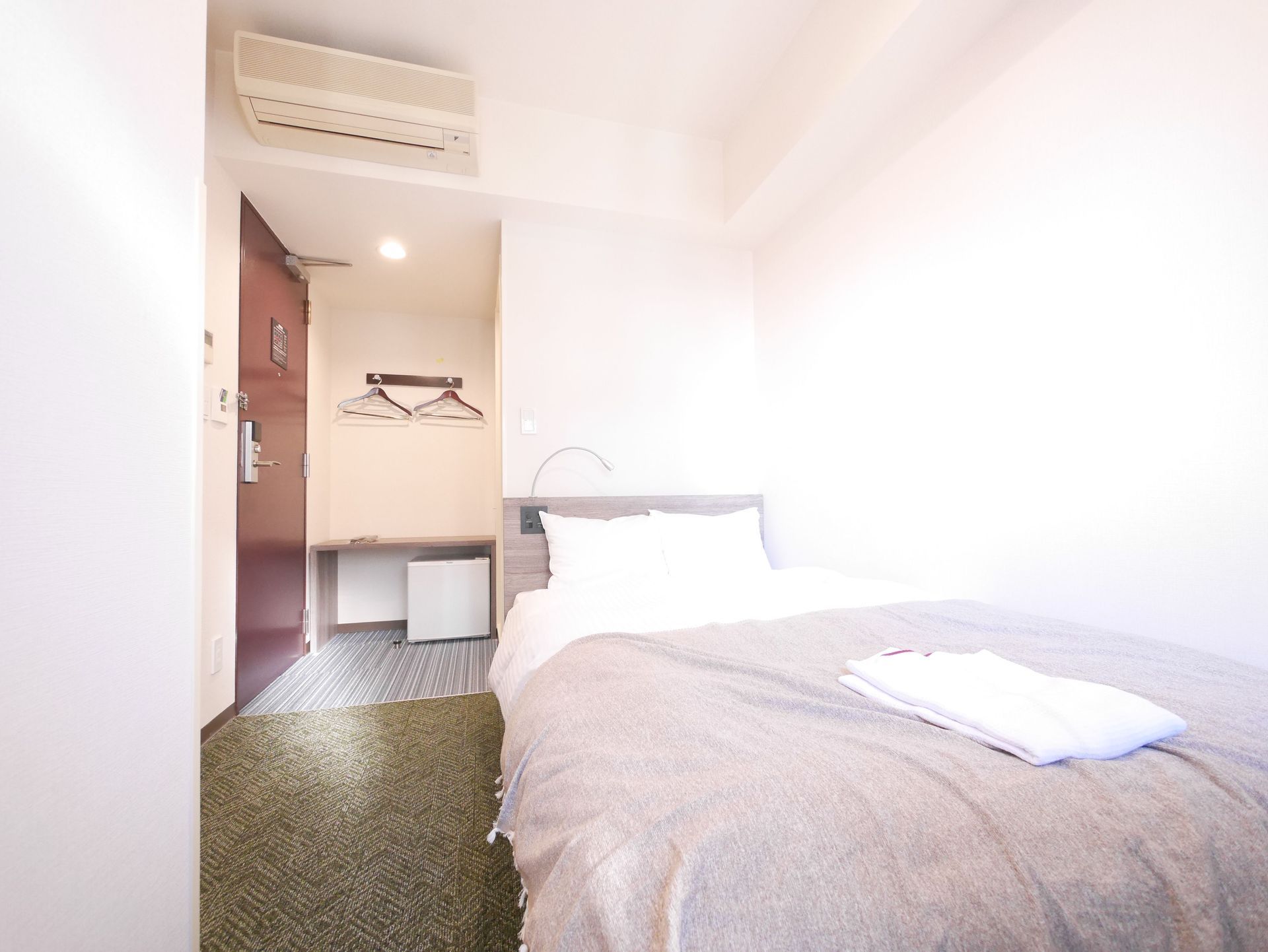 Compact single room layout with hallway and bed