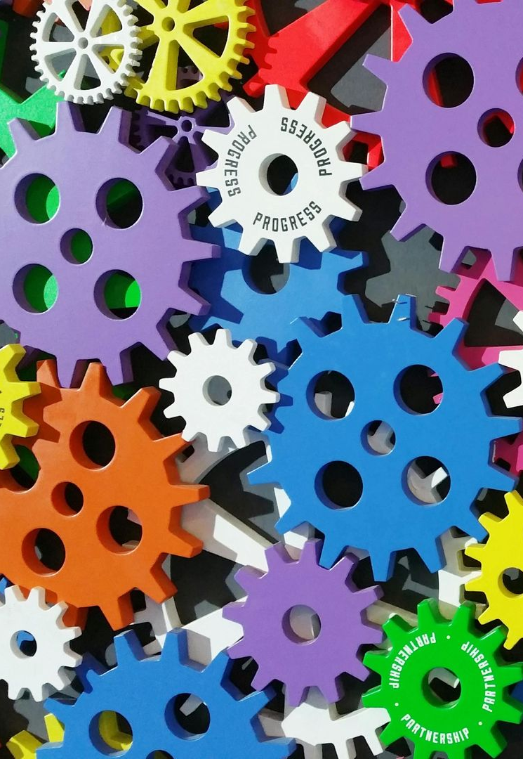 Colorful gears, overlapping against a dark background. With some text saying 
