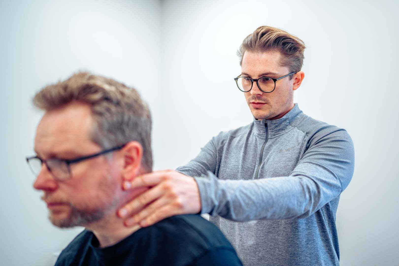 Essex Physiotherapist neck pain treatment - An image of a woman holding her neck