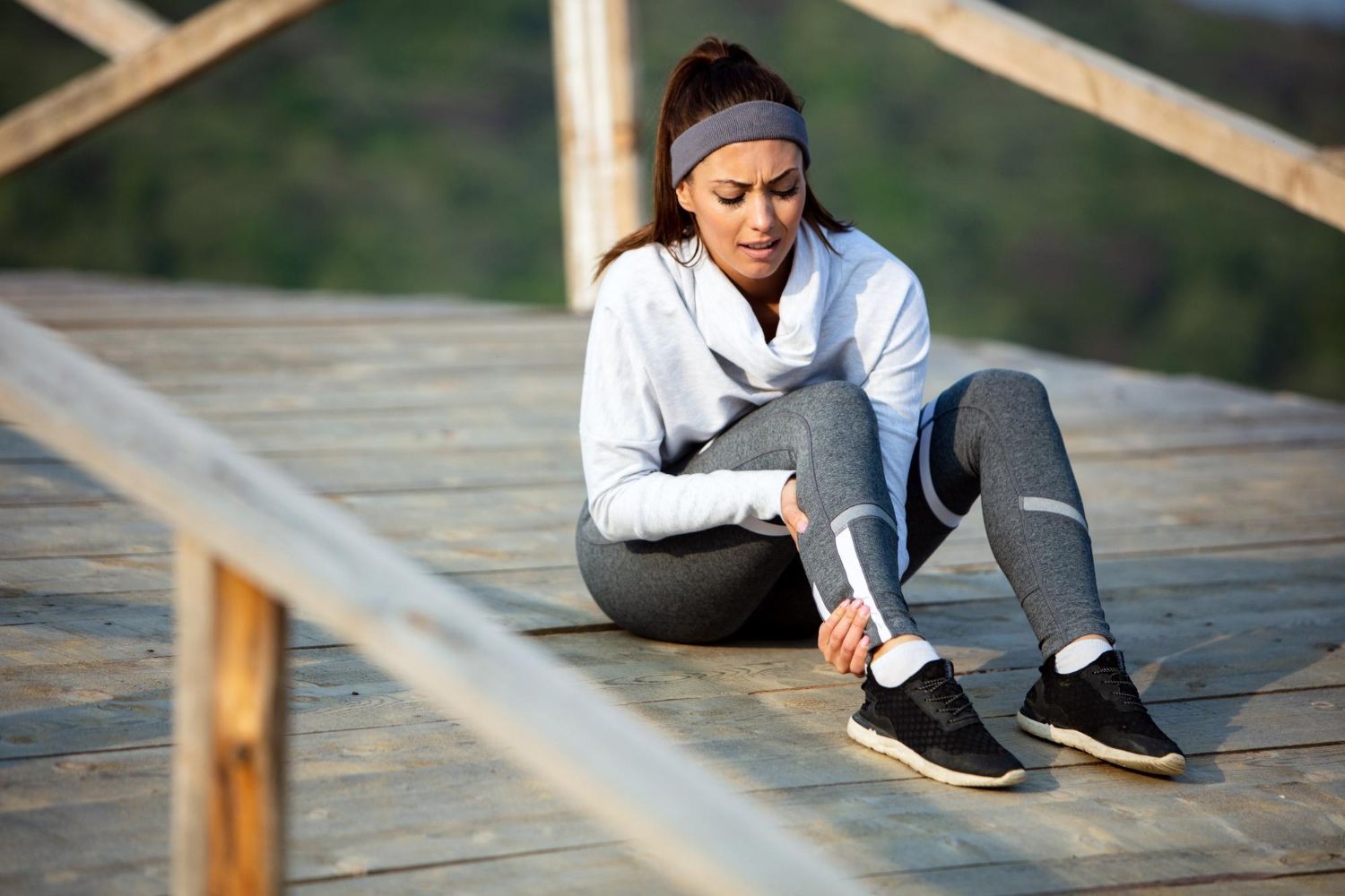 Essex Physiotherapist - achillies pain - an image of a woman clucthing her leg after a run