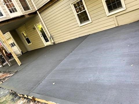 A concrete patio is being built in front of a house.