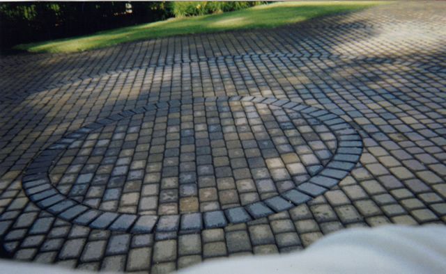 A brick driveway with a circle in the middle