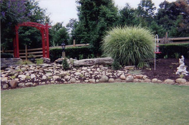 A lush green lawn with a red arch in the background