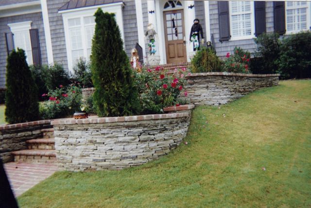 A house with a stone wall in front of it