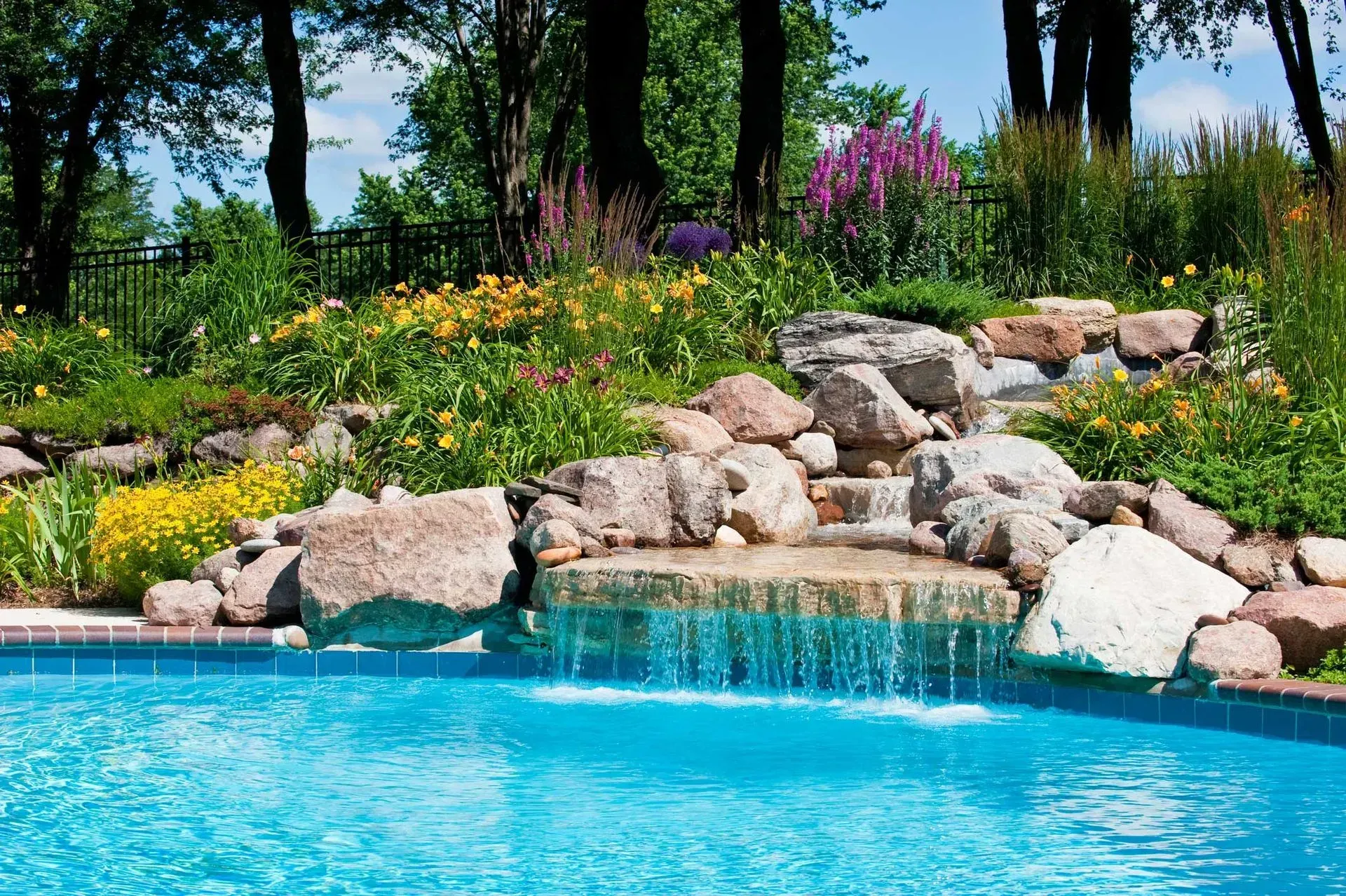 A swimming pool with a waterfall in the middle of it