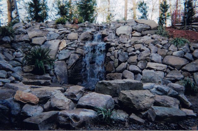 A waterfall is surrounded by rocks and trees