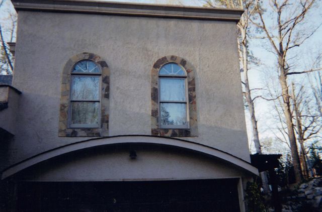 A building with two arched windows and a garage