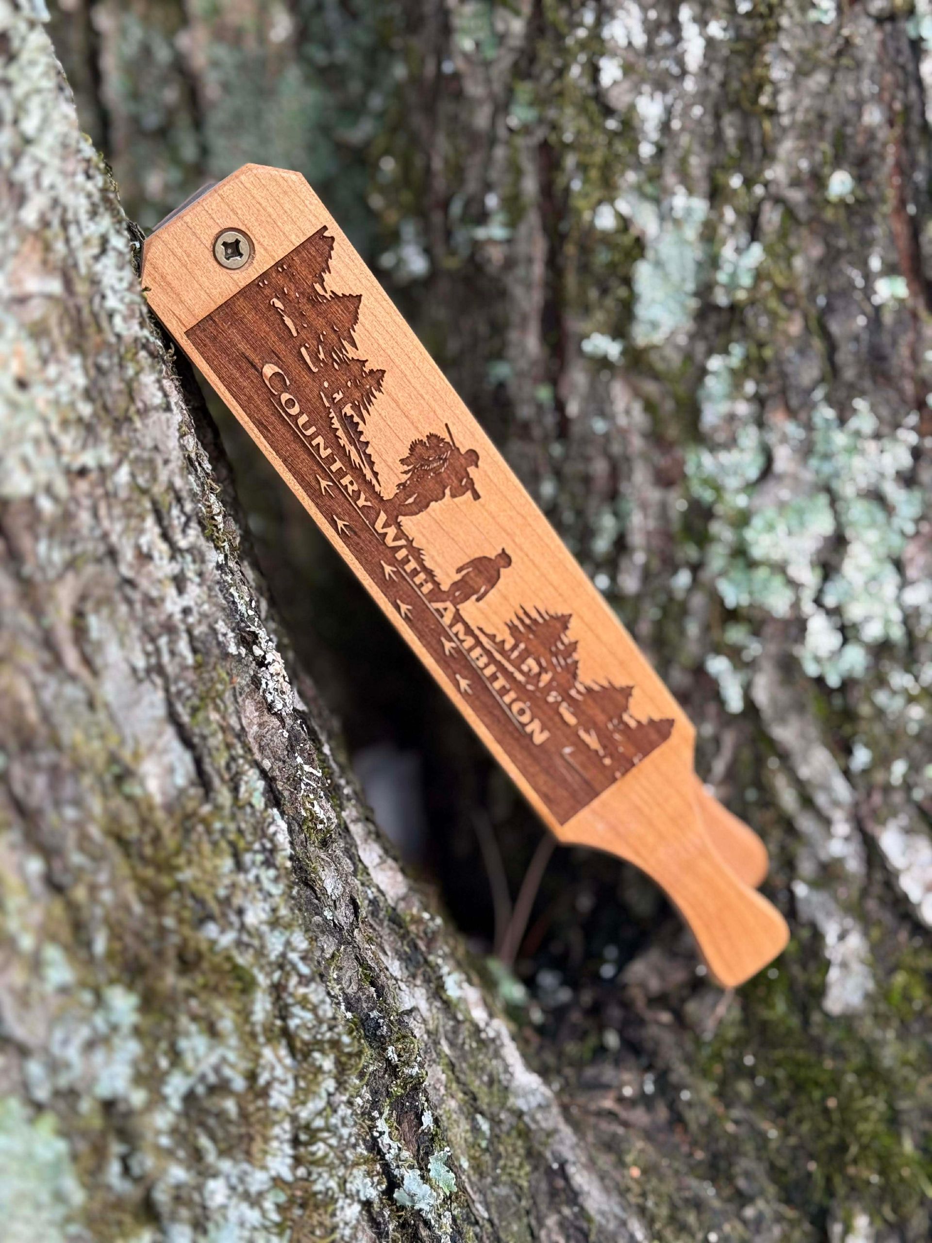 Wooden turkey box call engraved with a forest scene