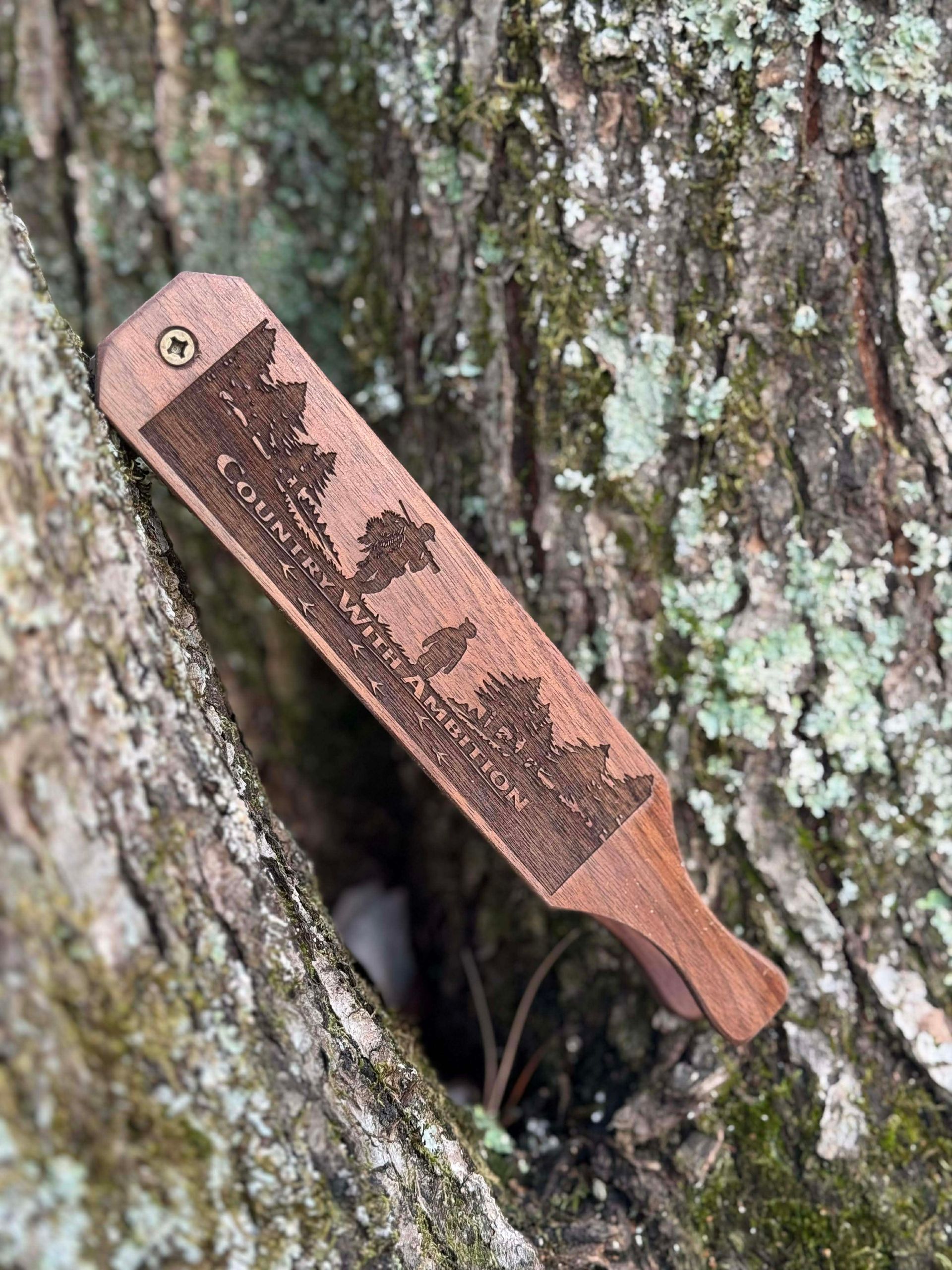 Wooden turkey box call engraved with a forest scene