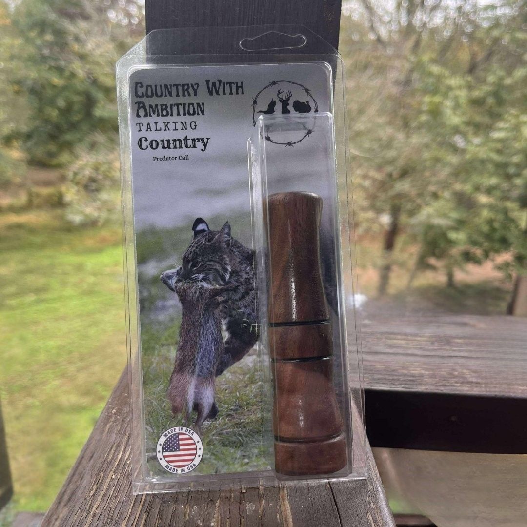 Wooden hand turned predator call on a dark rock, surrounded by leaves. Country with Ambition