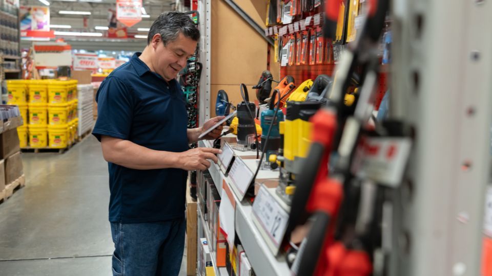 Um homem atualizando o estoque de uma loja de ferragens