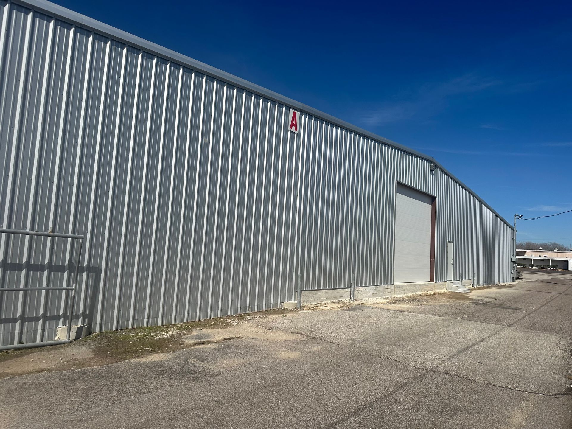 A large gray metal building with a blue sky in the background.