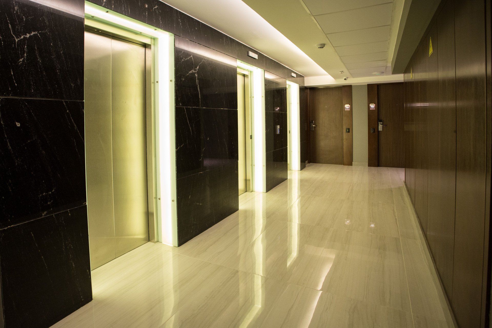 Uma fileira de elevadores estão alinhados em um corredor