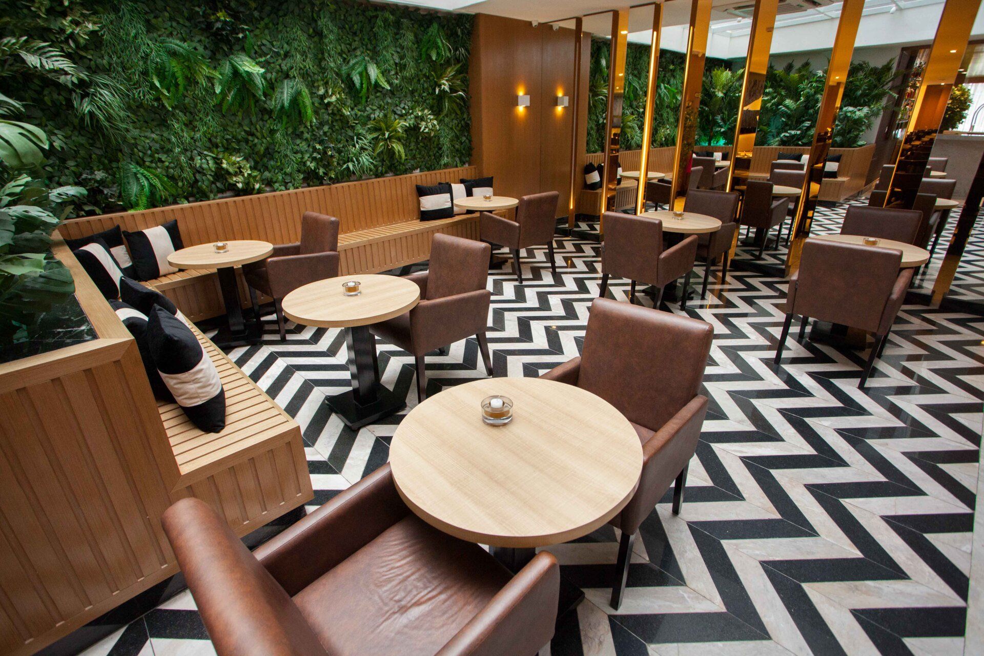 Um restaurante com mesas e cadeiras e um piso em zigue-zague preto e branco.