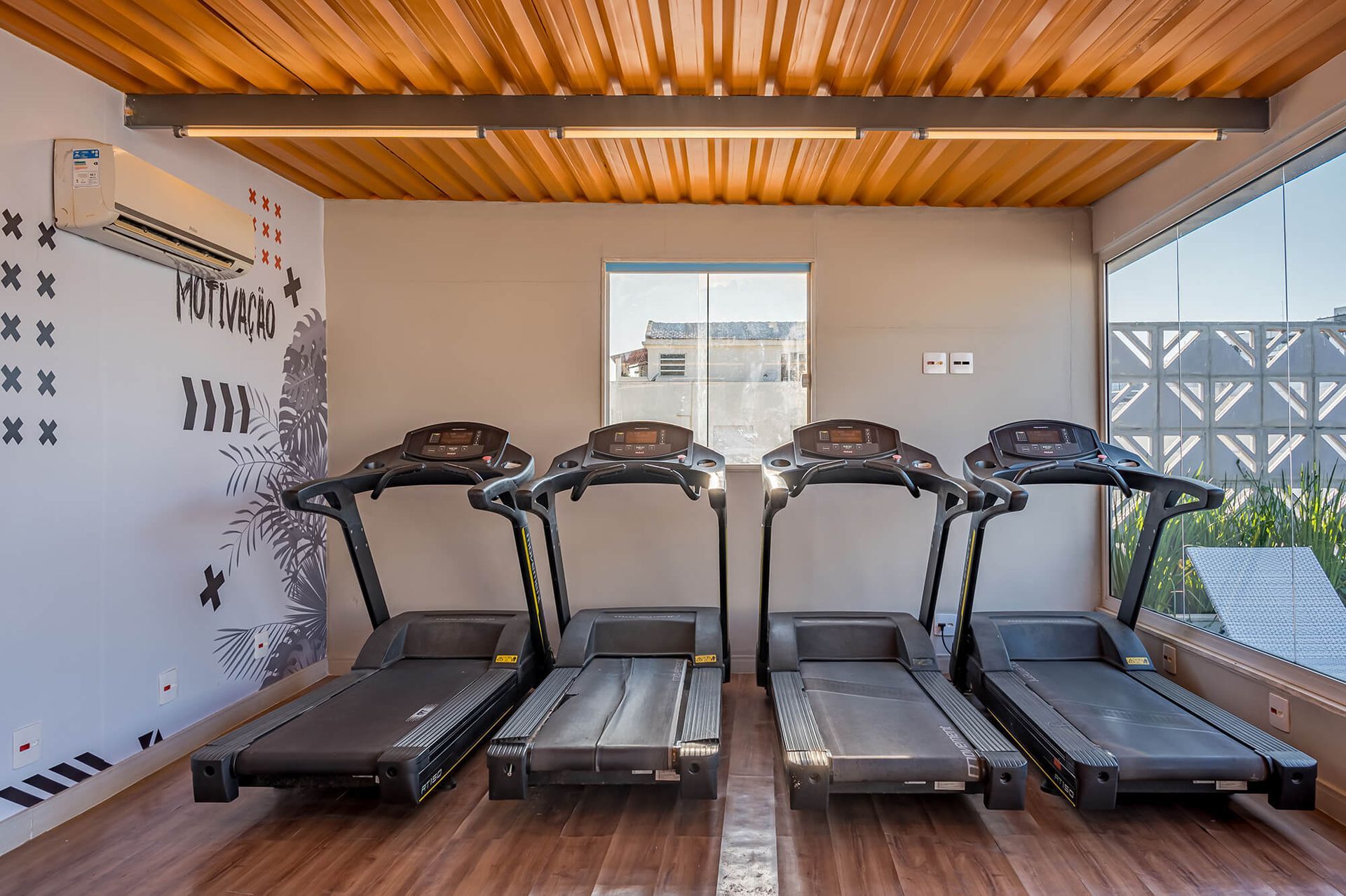 Uma fileira de esteiras estão alinhadas em uma academia.