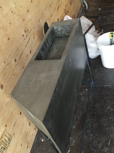 Un évier en acier inoxydable est posé sur un plancher en bois