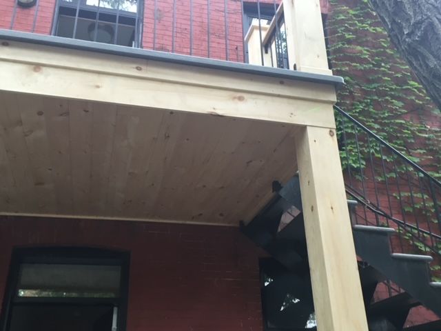 Un porche en bois avec des escaliers qui y mènent