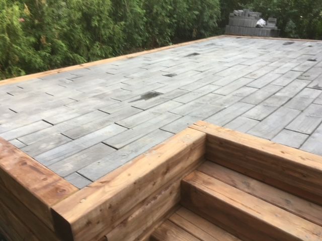 Une terrasse en bois avec des escaliers qui y mènent