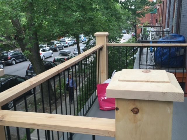 Une balustrade en bois sur un balcon donnant sur une rue de la ville